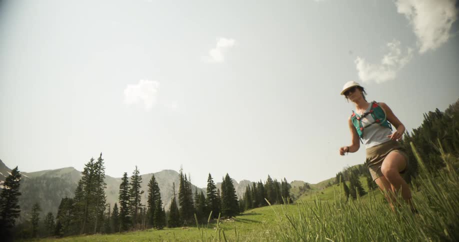 A young woman running through a field outdoors during daytime