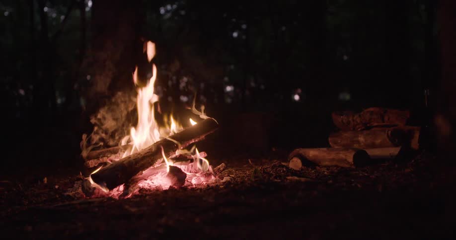 The campfire gives off smoke and sparks