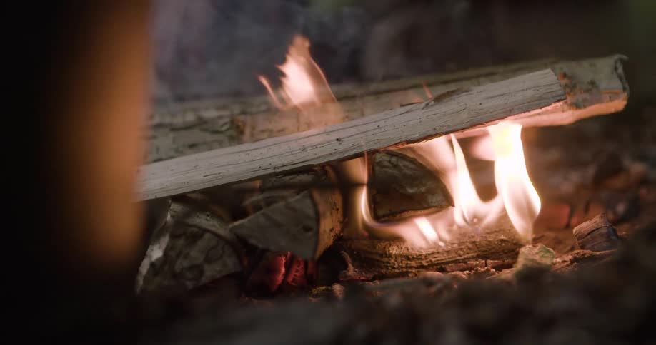 The flames engulf the sticks in the campfire