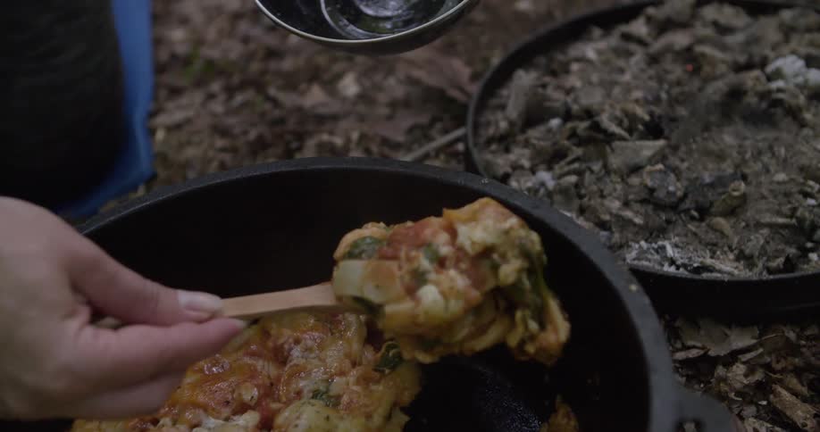 The woman serves food at the camp site