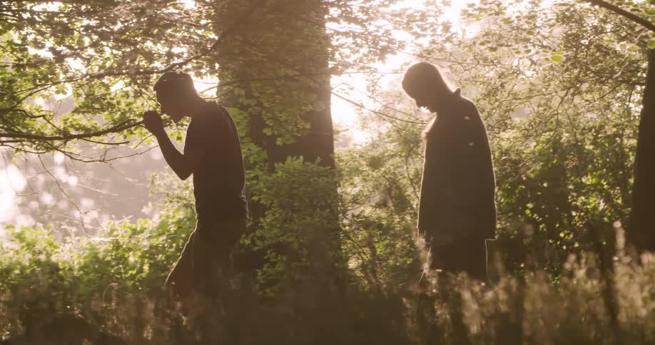 The man and woman are hiking in the woods