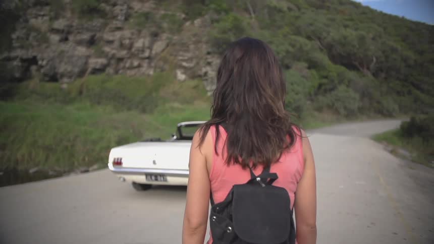Woman standing in front of a convertible