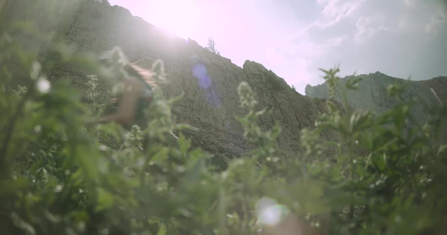 The woman runs uphill by the mountain
