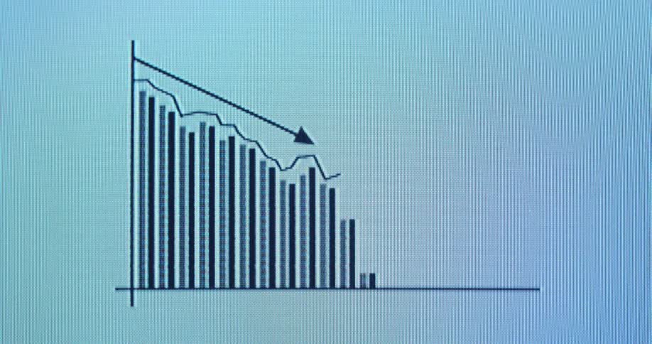 CRT or cathode ray tube monitor with RGB pixels displaying animated bar chart with negative trend line and downward pointing arrow going down as the business expenses are lowered or the profit is declining due to bad economic development