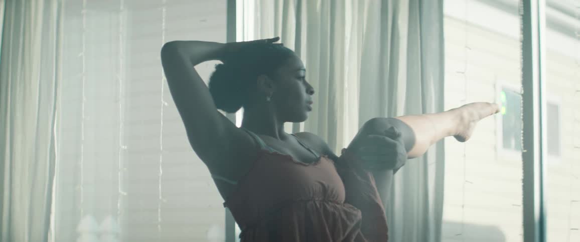 Ballerina in an indoor space lifting her leg in a performance