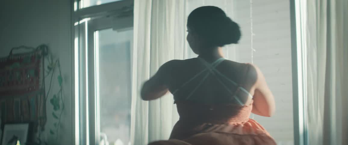 Black female dancer spins repeatedly by the window