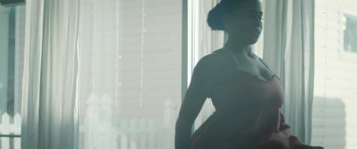 The woman sins as the sunlight hits her from the window