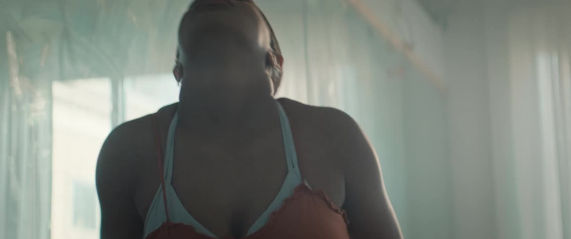 The woman watches herself in the mirror as she dances