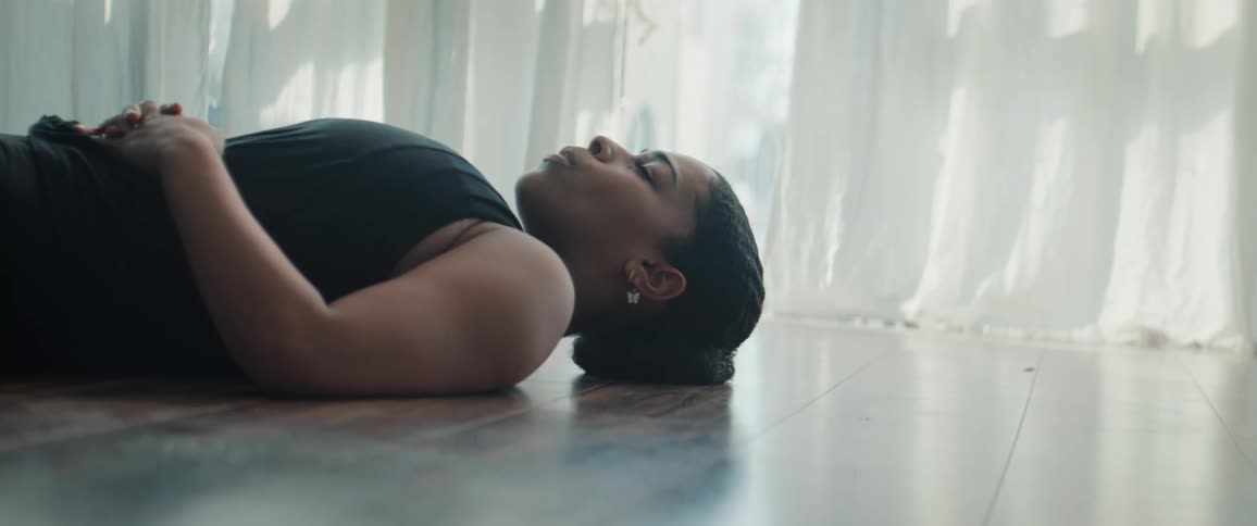 Woman lying on the floor and deep breathing with a serious face