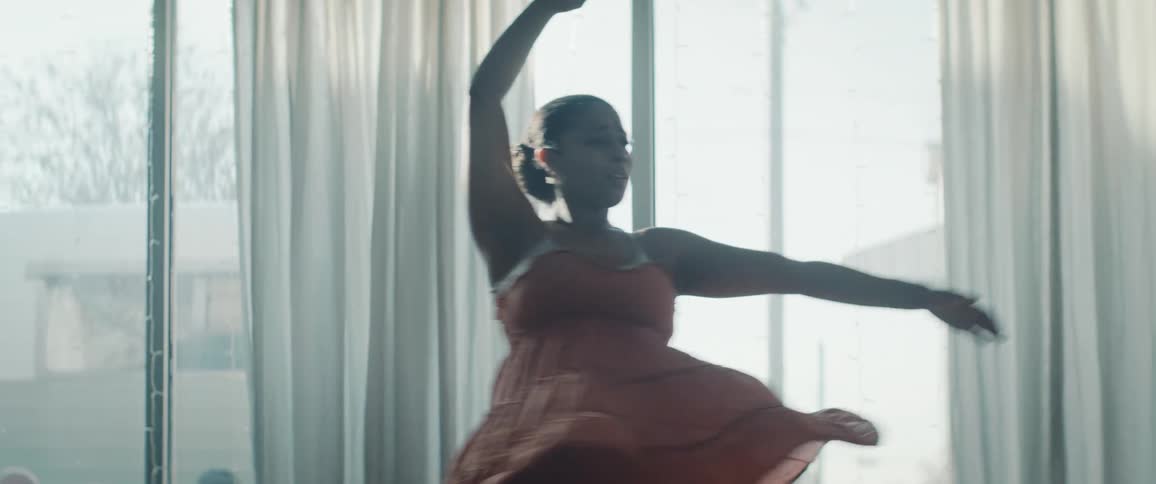 The dancing woman looks up while swinging her arms