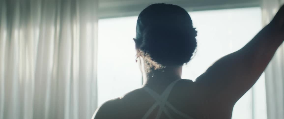 The woman touches her back as she dances