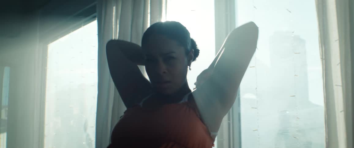 A black female dramatically dances in a sunlit room