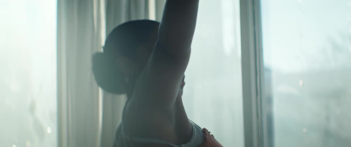 Black Female is dancing and swaying by the window