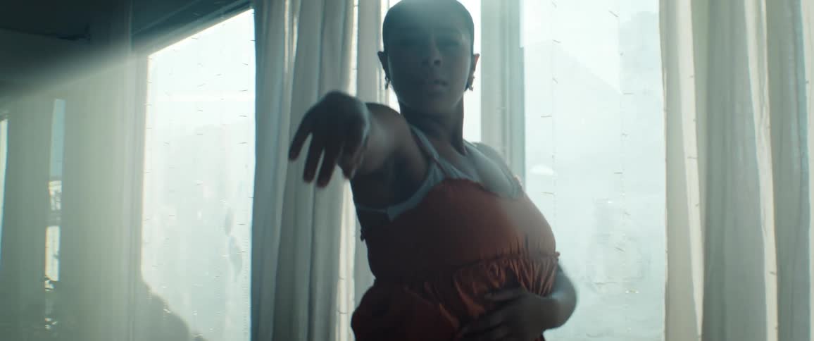 Afican Woman in a ballroom wearing an orange dress dancing