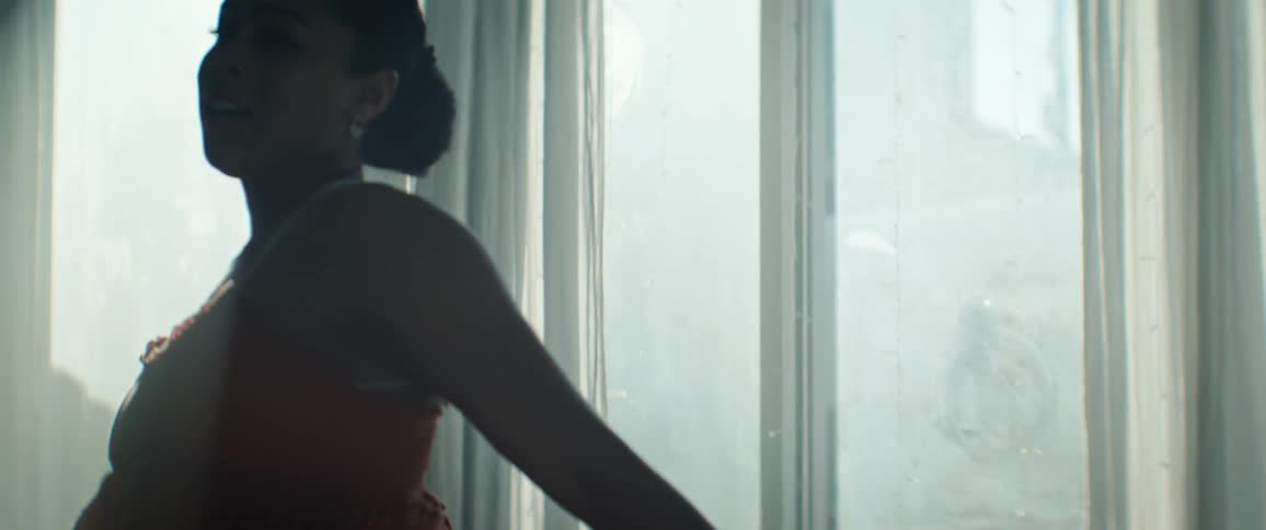 Ballerina dancing in a performance with an orange dress in an indoor space