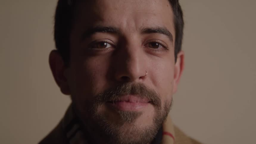 Man looks with a serene expression and a slight smile