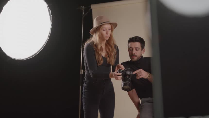Woman shows the result of the capture to a man in a welllit studio