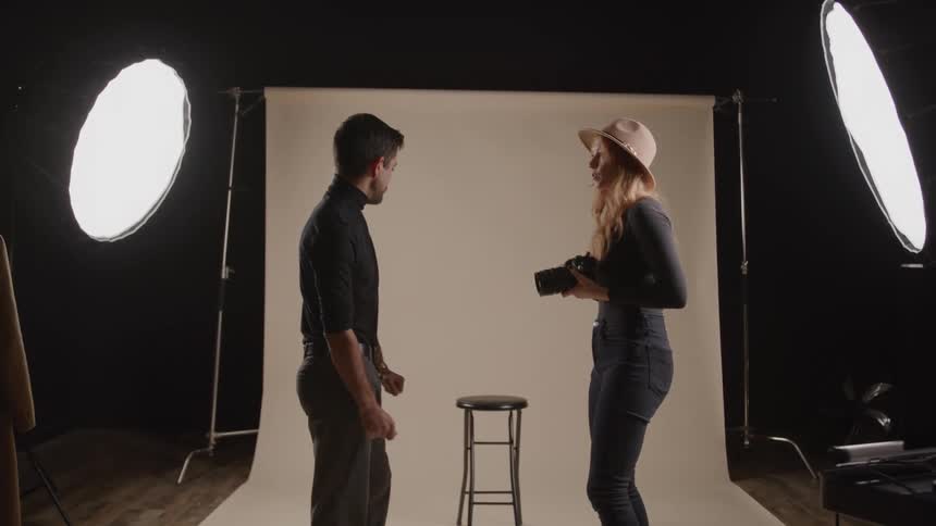 Woman shows the result to the man in a studio with professional lighting
