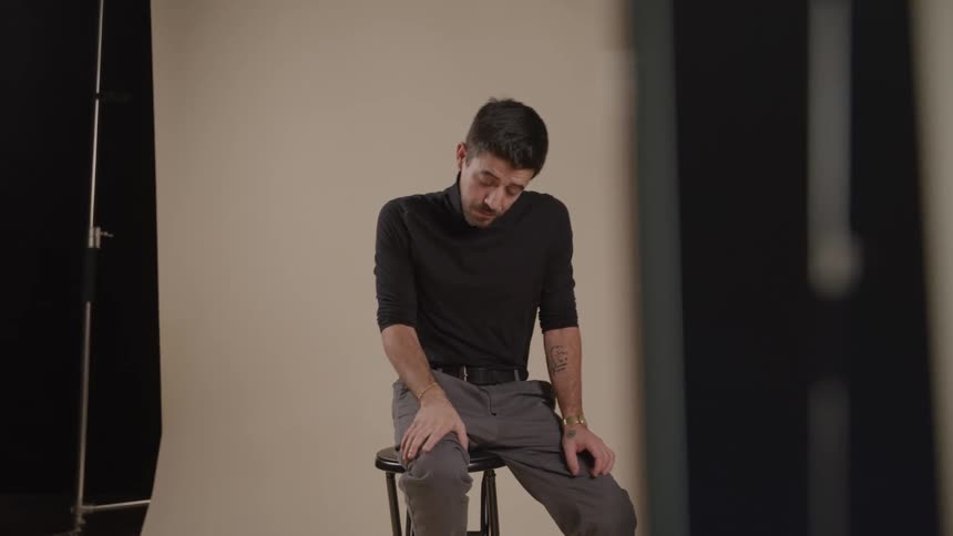 Male model posing and talking with a female photographer indoors