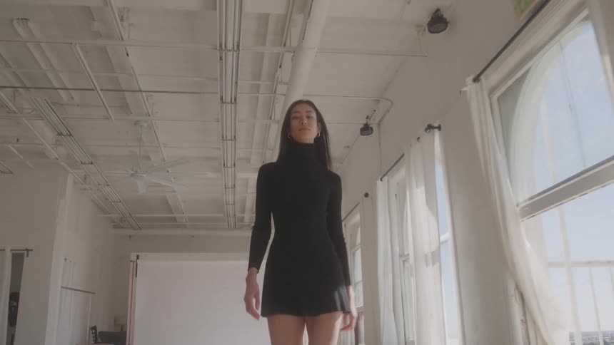 Woman walks with confident posture through a bright studio