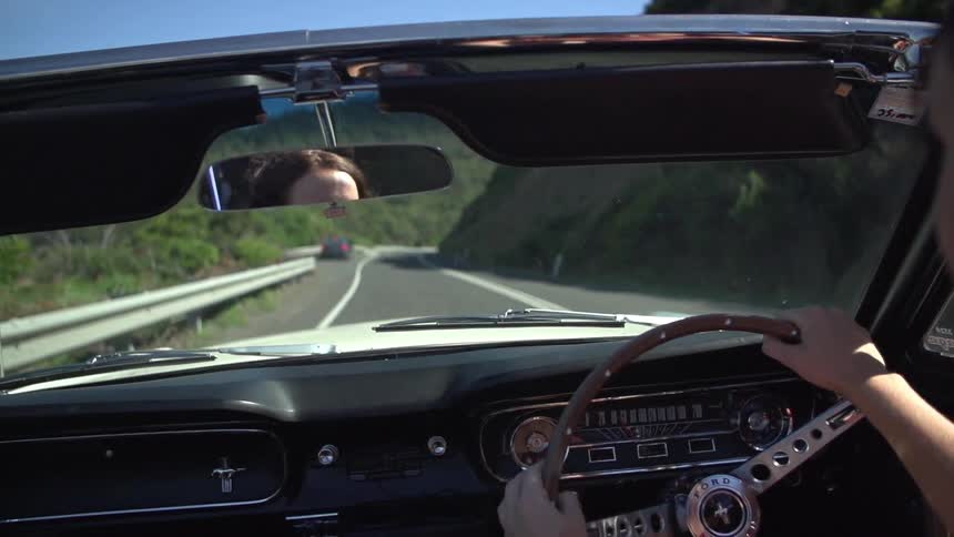A woman driving a vehicle down a road