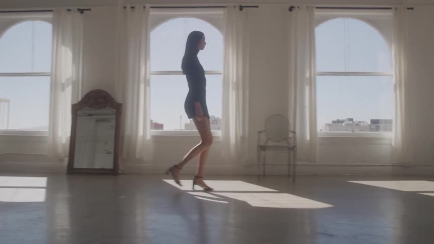 Woman walks gracefully through the studio bathed in natural light