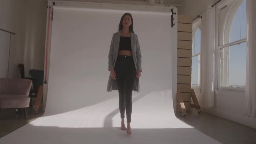 The woman walks and poses in the studio