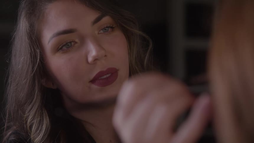 Woman focuses while applying makeup to another person with precision