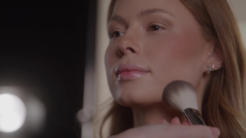 Woman having makeup applied with a brush on their face