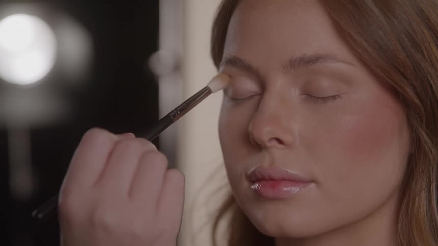 Makeup being applied to the eyelid with a brush