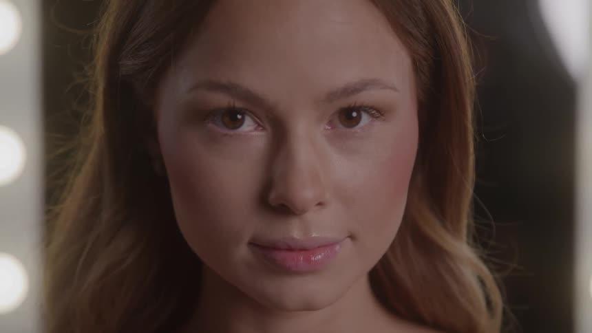 The woman smiling is wearing makeup