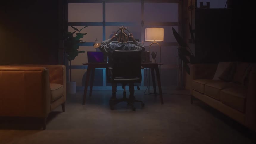 Woman works on a computer in an indoor space with soft lighting and cozy decor