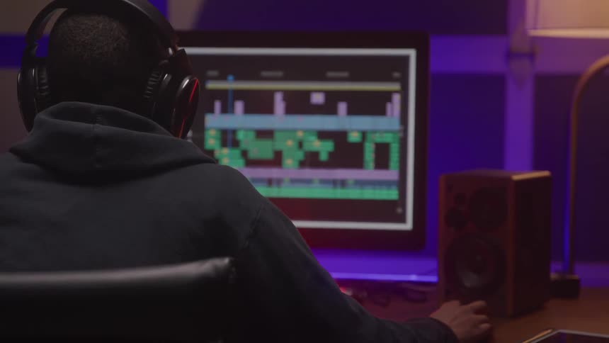Person wearing headphones works on video editing at the computer