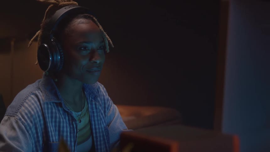 Woman wearing headphones looks at the computer screen in an editing environment