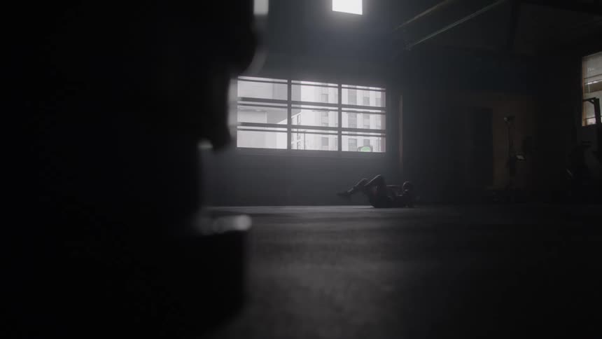Person exercising on the gym floor with soft light in the background