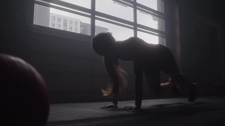 A person works out on the gym floor by a large window
