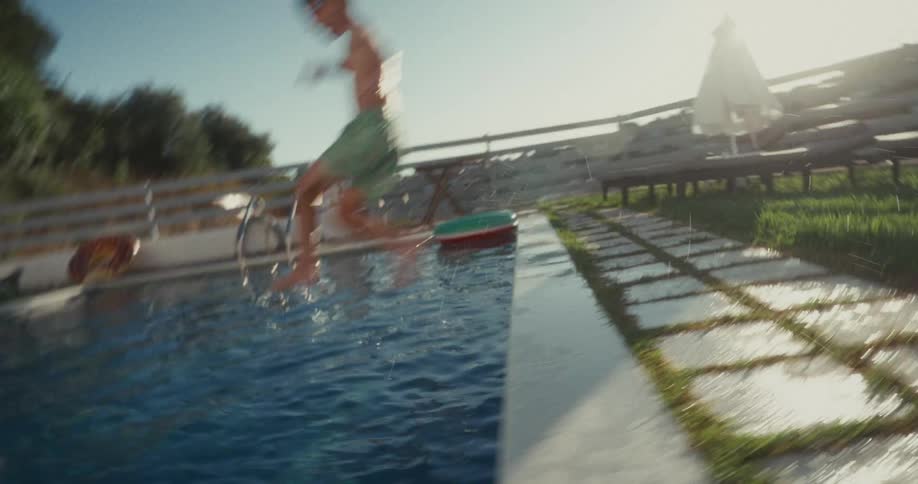 Child joyfully jumping into the pool on a sunny day