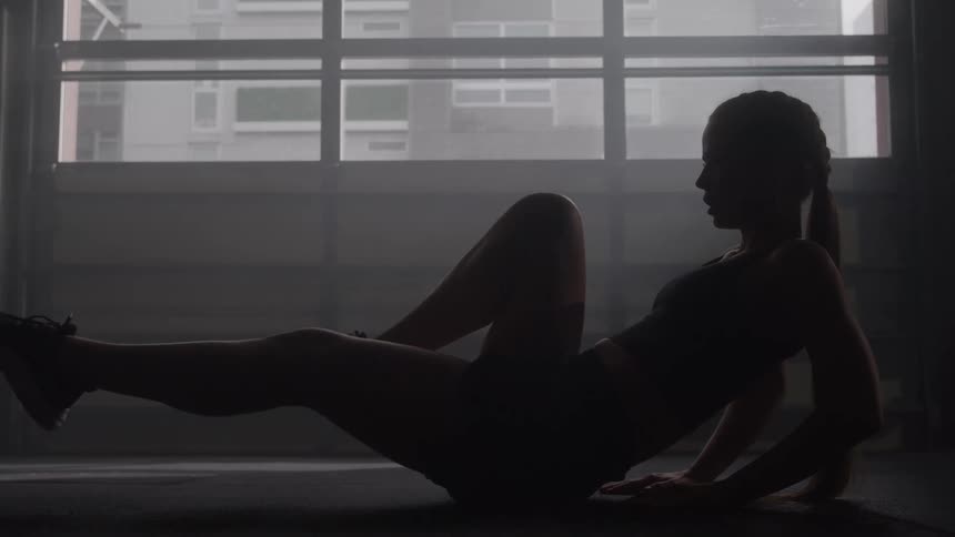 Woman performs an abdominal exercise on the gym floor