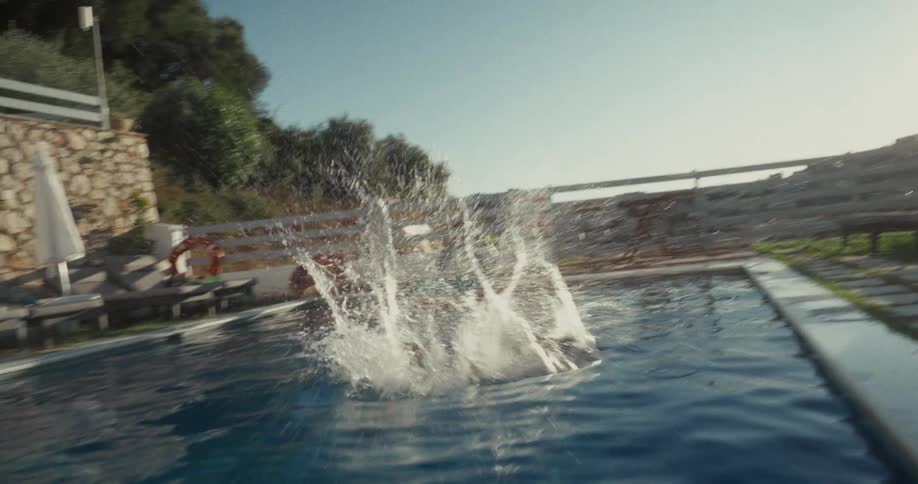 Child running and jumping toward the pool on a sunny day