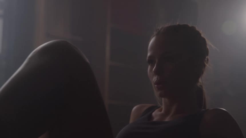 Woman doing situp in dimly lit setting