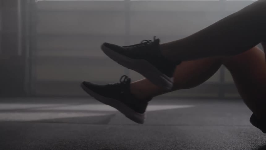 Raised legs perform an abdominal exercise on the gym floor