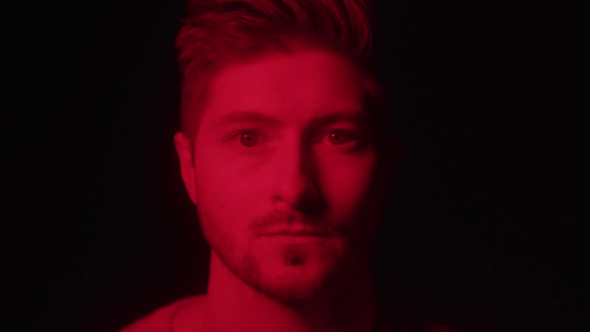 Man stares under intense red lighting