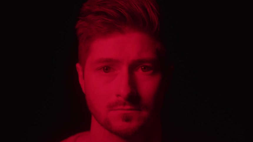 Male face illuminated by intense red light