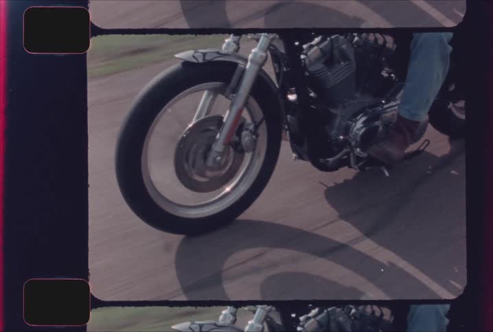 The motorcycle moves down the road on a sunny day