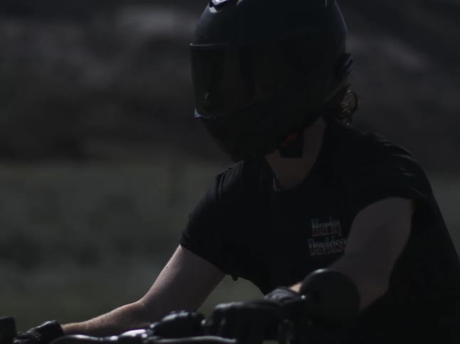 Wind blows the mans hair as he rides on the motorcycle