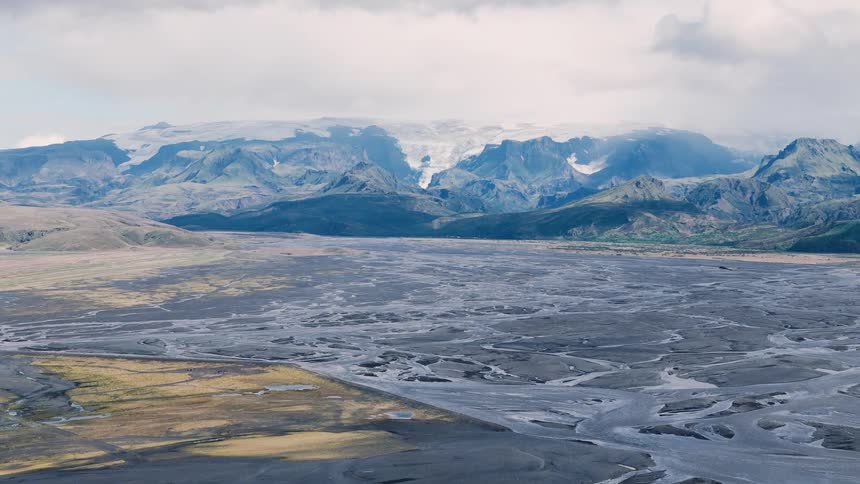 Meandering alluvial plain at the foot of glaciercovered mountains