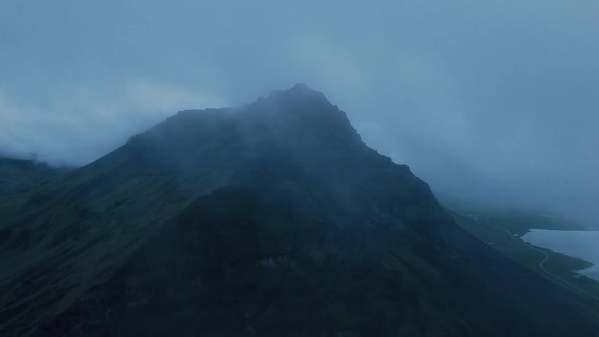 Imposing rocky peak under a cloudy sky at dusk
