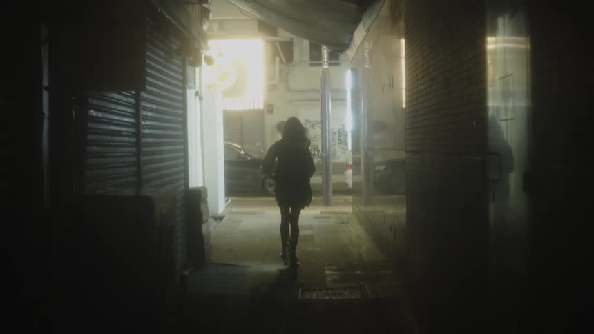 The woman rides her bike down the alley