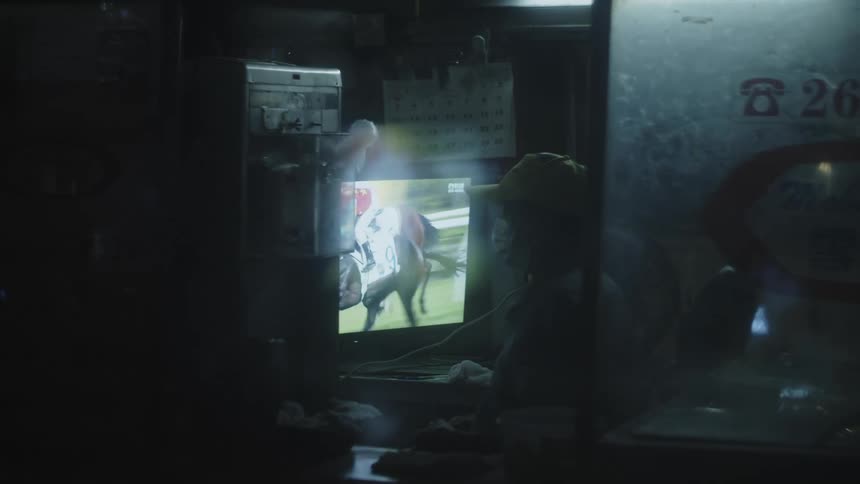 Man watching horse racing broadcast on tv at home