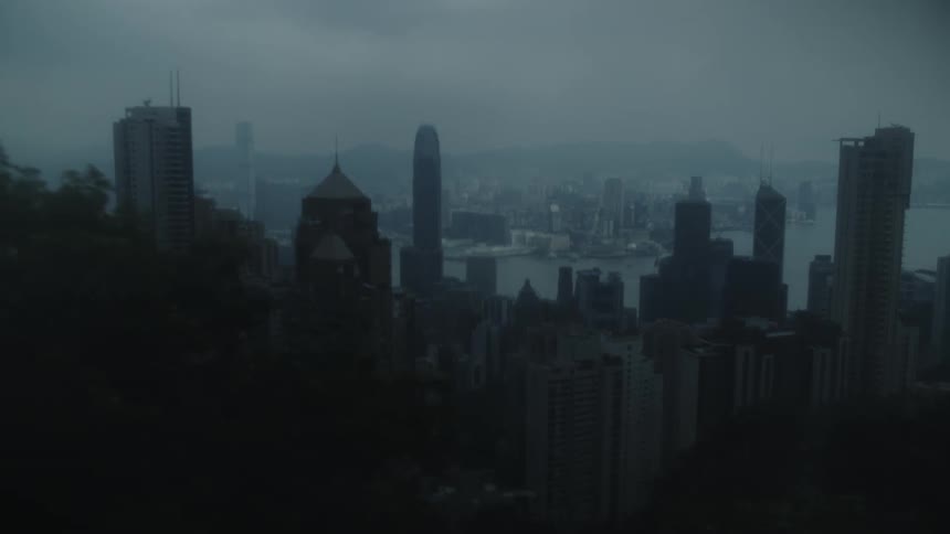 Panoramic view of skyscrapers under a cloudy sky by the edge of a bay